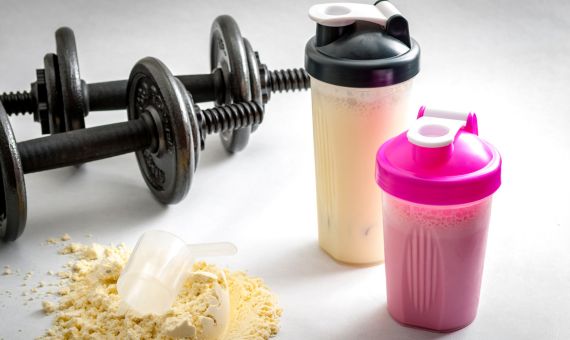 two bottles of protein powder and weights