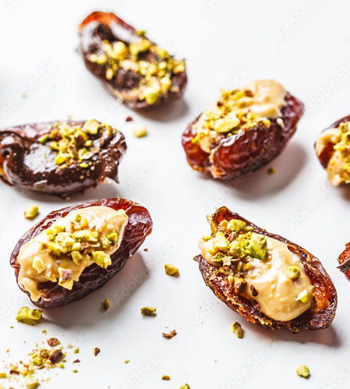 Stuffed dates topped with creamy filling and crushed pistachios